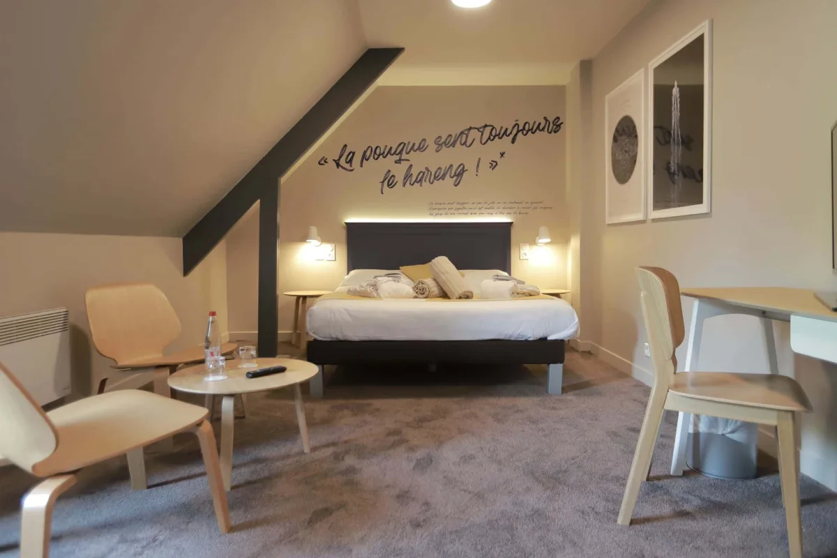Chambre Double Privilège de l’Hôtel Antares & Spa Honfleur, décor moderne, coin salon lumineux et message mural inspirant.