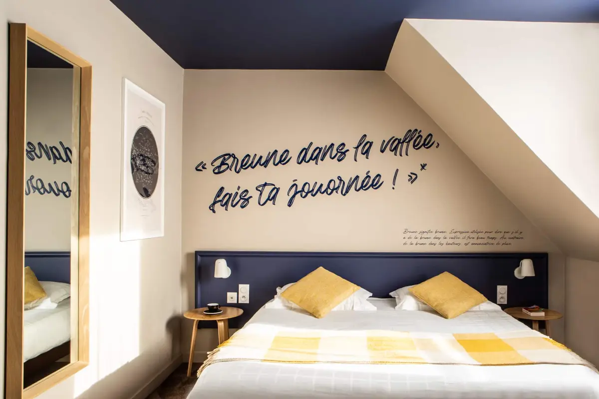 Chambre double Twin Cosy de l’Hôtel Antares & Spa Honfleur, avec lit twin, décoration moderne et message mural « Brume dans la vallée, fais ta journée ! ».