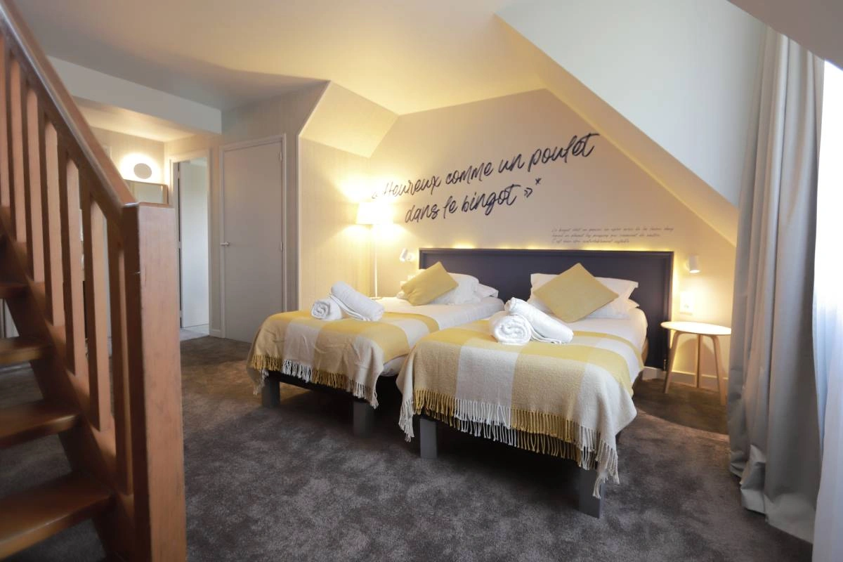 Chambre quadruple en duplex de l’Hôtel Antares & Spa Honfleur, avec deux lits, mezzanine et décoration chaleureuse sous combles.