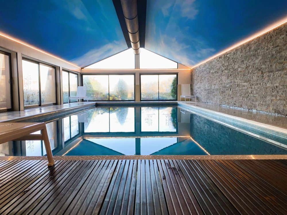 Heated indoor swimming pool at Hotel Antares Honfleur with large windows