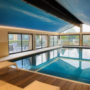 Piscine du Spa de l'Hôtel Antarès Honfleur illuminée de nuit, ambiance feutrée