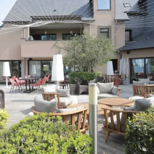 Terrasse avec salon de jardin, tables et verdure de l'Hôtel Antarès Honfleur